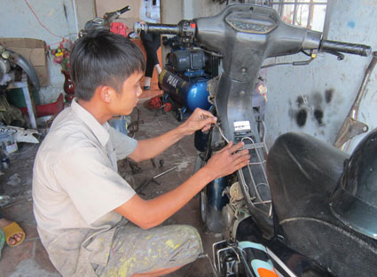 Nguyễn Anh Kiệt sửa xe cho khách tại cơ sở của mình.