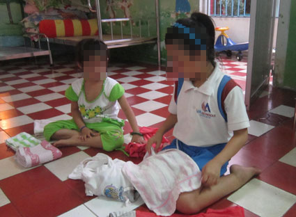 Trẻ em bị nhiễm HIV vẫn được đi học bình thường, nhưng các em luôn lo sợ bị mọi người phát hiện ra bệnh của mình. Trong ảnh: Em Lê Thanh M. (phải), ở Trung tâm bảo trợ trẻ em Vũng Tàu đang sắp xếp quần áo.