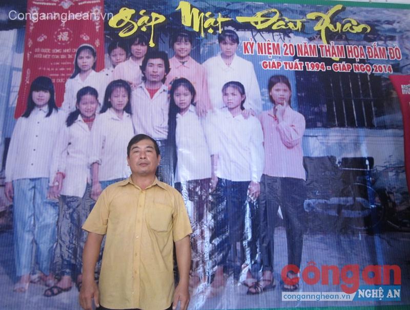 Anh Bùi Đức Vinh đứng bên bức ảnh chụp 20 năm về trước với các cháu sau khi bị đắm đò
