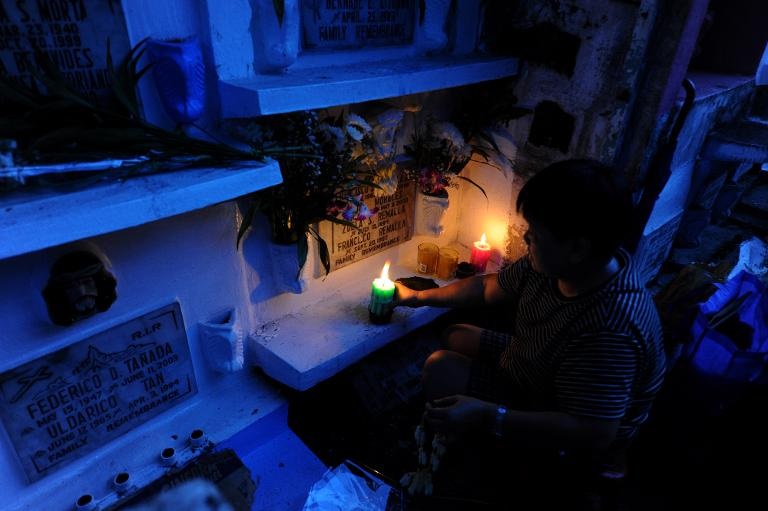 Thắp nến, đặt hoa và cầu nguyện tại ngôi mộ đá của những người thân yêu đã ra đi tại một nghĩa trang ở Manila, đây là một hoạt động truyền thống hàng năm