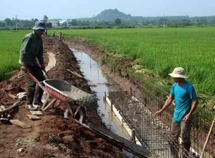 Cứ mỗi tiêu chí đạt được trong xây dựng NTM, bộ mặt nông thôn lại có sự đổi mới. Trong ảnh: Bê tông hóa hệ thống kênh tưới nước tại cánh đồng xã An Nhứt, huyện Long Điền.
