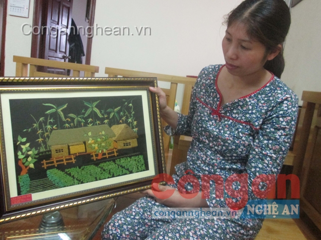 Chị Hồ Thị Diệu Thúy bên bức tranh thêu tay về quê nội Bác Hồ