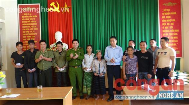 Đại diện lãnh đạo Phòng An ninh xã hội Công an tỉnh, Công an huyện Quế Phong trao quà cho người dân xã Nậm Giải