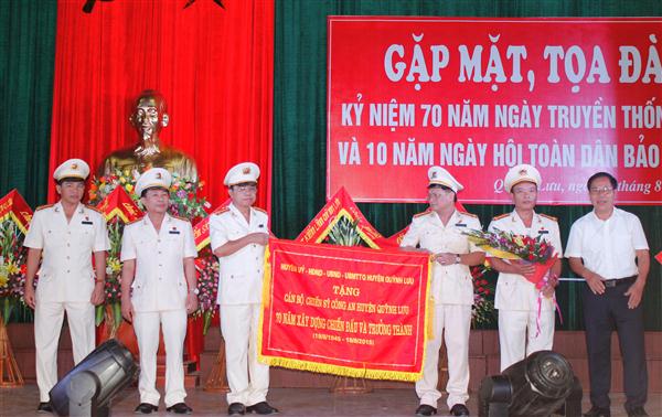 Đại diện lãnh đạo Huyện ủy, HĐND, UBND huyện tặng bức trướng: 70 năm xây dựng, chiến đấu và trưởng thành cho Công an huyện Quỳnh Lưu.