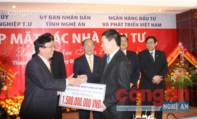 Cộng đồng doanh nghiệp đồng hành với công tác xã hội, xóa đói giảm nghèo                          trên địa bàn tỉnh (Trong ảnh: Đại diện các nhà đầu tư trao tiền hỗ trợ                    các xã nghèo tại Hội nghị xúc tiến đầu tư) 