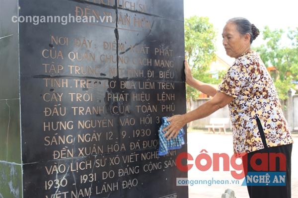 Bà Nguyễn Thị Hường lau bia dẫn tích tại đền Xuân Hòa, di tích gắn liền                     với sự kiện ngày 12/9/1930