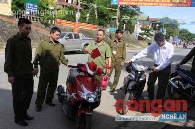 Ban Công an thị trấn Hoà Bình nhắc nhở người dân để xe đúng nơi quy định, không lấn chiếm hành lang ATGT