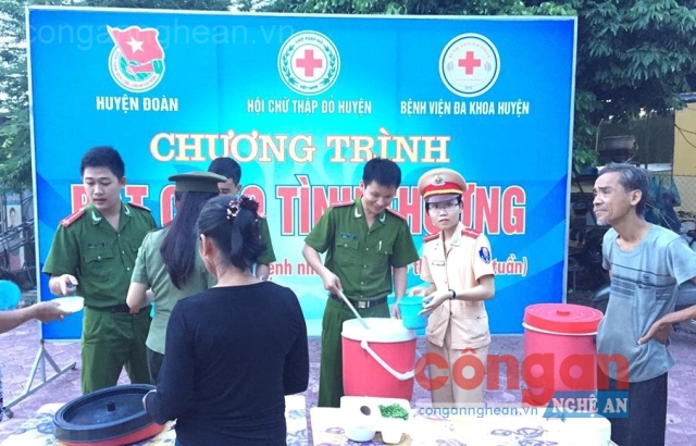 Các cán bộ chiến sỹ Công an huyện Thanh Chương phát cháo cho bệnh nhân.