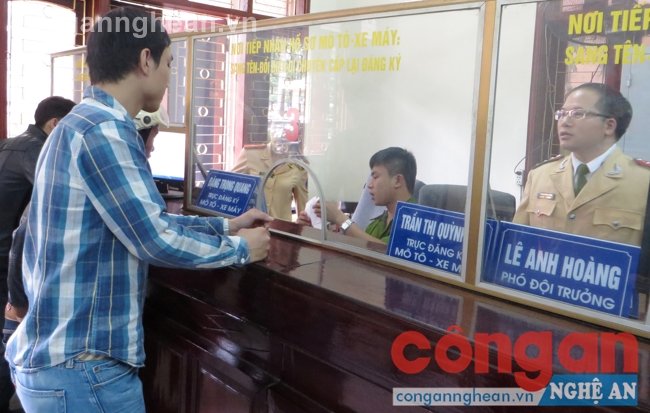 Cán bộ Đội Đăng ký quản lý xe lái Phòng CSGT đường bộ, đường sắt hướng dẫn người dân làm thủ tục đăng ký xe