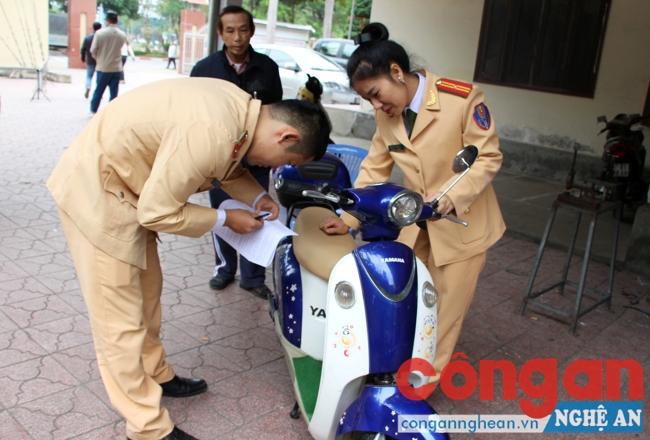 Cán bộ Phòng CSGT đường bộ, đường sắt kiểm tra số khung, số máy để làm thủ tục cấp biển số xe máy điện cho chủ phương tiện