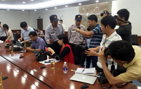 Nhân viên an ninh công ty FHS kiểm tra giấy tờ của các phóng viên