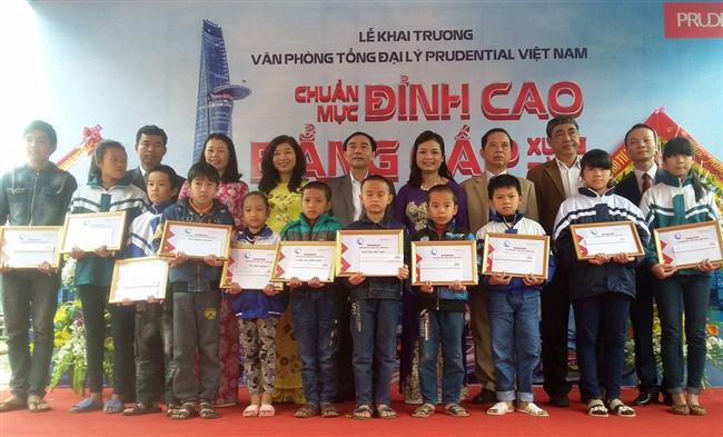 Đại diện lãnh đạo Prudential cùng lãnh đạo địa phương                                trao quà cho học sinh nghèo hiếu học