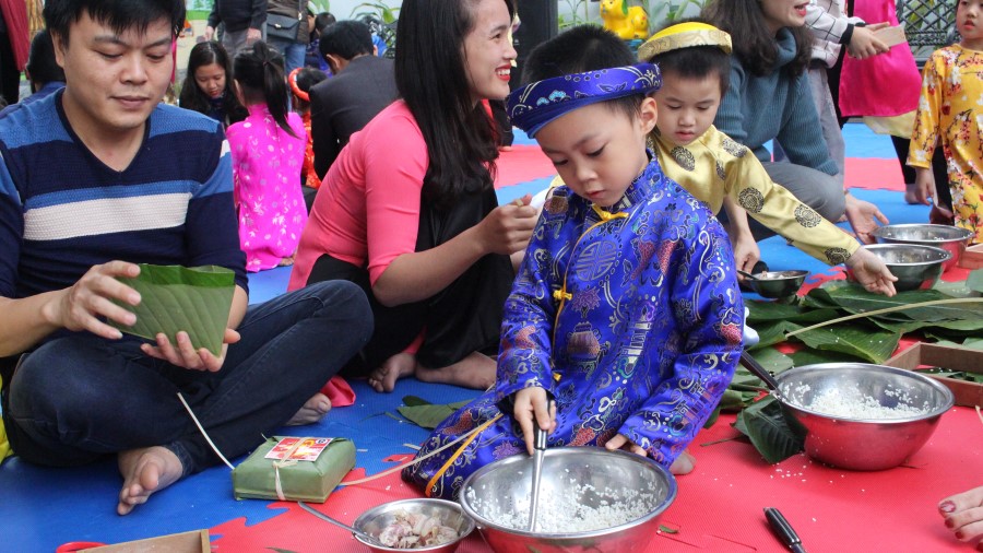 Bé trai giúp bố nhóm nếp lại để cho vào bánh