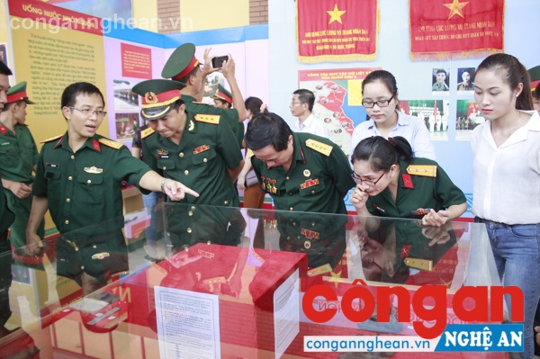Đại biểu tham dự triển lãm nghe thuyết minh qua các hiện vật và tham quan triễn lãm