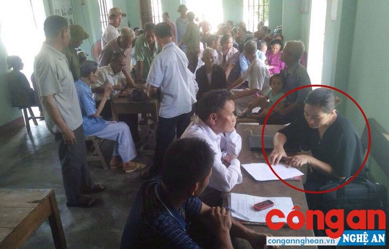 Một phụ nữ trong nhóm người của Công ty Đức Minh vận động hội viên người cao tuổi chụp ảnh “dịch vụ”