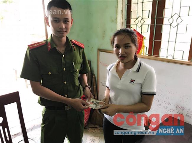 Thiếu úy Nguyễn Văn Lập, cán bộ Đội Điều tra Tổng hợp trao trả số tiền bị mất cho chị Nguyễn Thị Hồng Giang