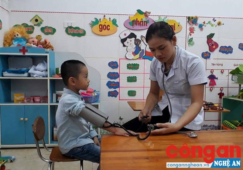 Cán bộ y tế Trường Mầm non Nghi Đức, TP Vinh khám ban đầu cho trẻ
