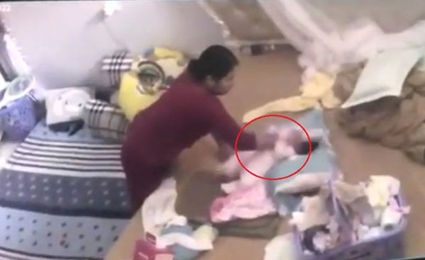 Người giúp việc có hành động quăng quật cháu bé (ảnh cắt clip).