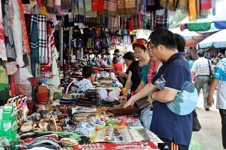 Khách du lịch nước ngoài mua đồ lưu niệm. Ảnh minh họa