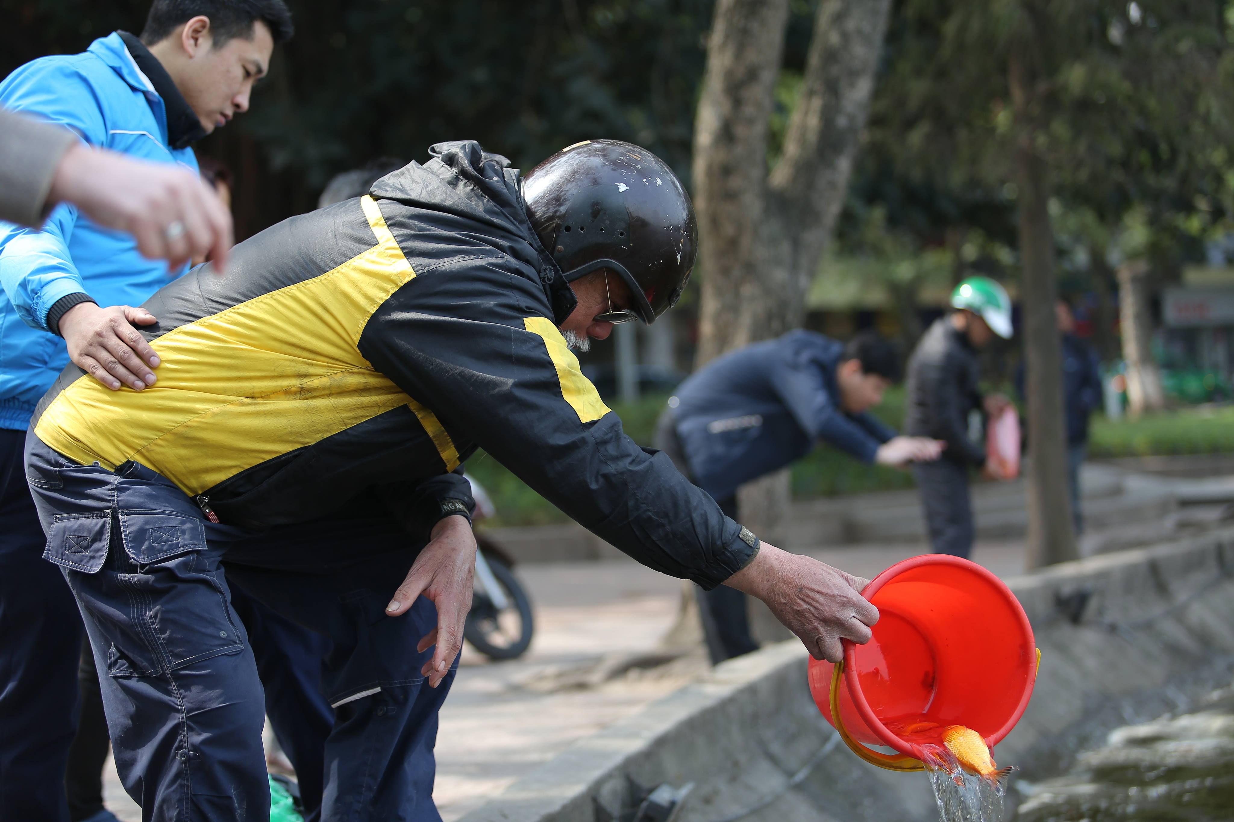 Một cụ già vẫn muốn trực tiếp thả cá nên con cháu phải giúp đỡ cụ