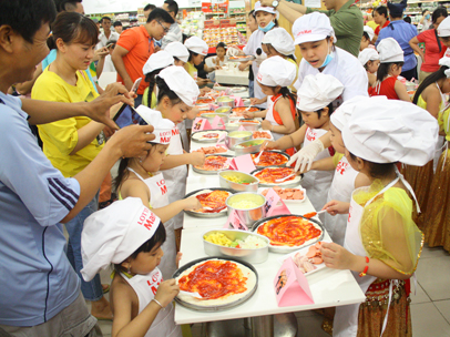 Các bé tham gia cuộc thi làm bánh pizza do đầu bếp của siêu thị Lotte Mart Vũng Tàu hướng dẫn.