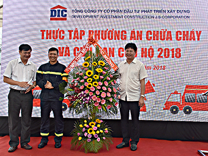 Đồng chí Nguyễn Thanh Tịnh, Phó Chủ tịch UBND tỉnh tặng hoa chúc mừng các đơn vị tham gia buổi thực tập phương án chữa cháy tại chung cư DIC Phoenix.