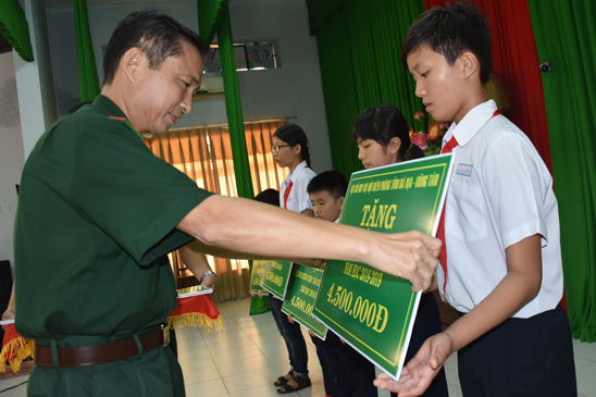 Đại tá Nguyễn Văn Thống, Phó Chính ủy BĐBP tỉnh trao quà cho HS có hoàn cảnh khó khăn.