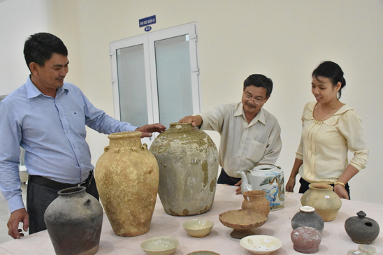Cán bộ Bảo tàng BR-VT tiếp nhận cổ vật, trong đó có những chiếc chum cổ thuộc nền văn hóa Gò Sành, niên đại thế kỷ 13, do ông Nguyễn Ngọc Ẩn hiến tặng. Ảnh HUY THANH