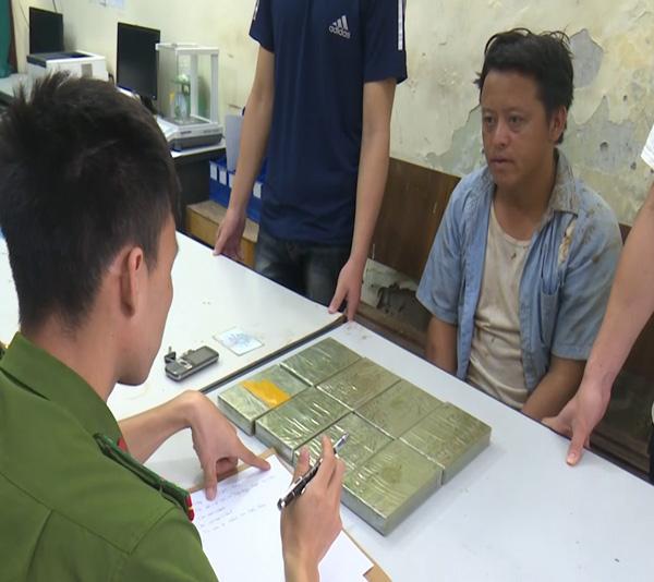 Đối tượng Vàng A Đô cùng tang vật 8 bánh heroin tại cơ quan Công an.