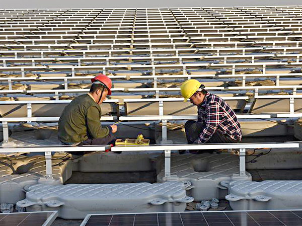 Công nhân làm việc tại Nhà máy điện mặt trời ở Hoài Nam, tỉnh An Huy, miền Đông Trung Quốc.  