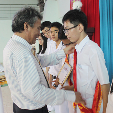 Thầy Lê Quốc Hùng, Hiệu trưởng Trường THPT chuyên Lê Quý Đôn trao phần thưởng cho 7 thủ khoa trong kỳ thi tuyển sinh lớp 10 vào trường.