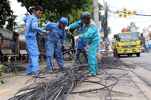Công nhân tiến hành tháo dỡ, di dời hệ thống cáp viễn thông trên đường Hà Huy Giáp (TP.Biên Hòa).
