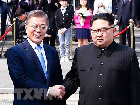 Tổng thống Hàn Quốc Moon Jae-in (trái) bắt tay hữu nghị Nhà lãnh đạo Triều Tiên Kim Jong-un (phải)  tại làng đình chiến Panmunjom. 