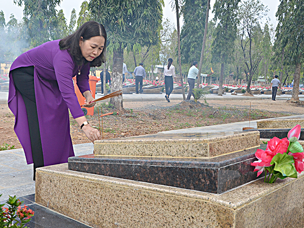 Đồng chí Nguyễn Thị Yến, Phó Bí thư Thường trực Tỉnh ủy, Trưởng Đoàn đại biểu Quốc hội tỉnh thắp nhang trên các phần mộ liệt sĩ. Ảnh: MINH NHÂN