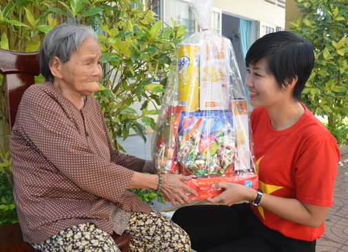 Tình nguyện viên nhóm từ thiện “Sunlife Việt Nam” tặng quà người già neo đơn xã Long Tân, huyện Đất Đỏ.