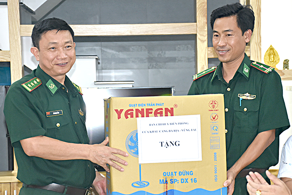Đại diện Ban Chỉ huy Biên phòng cửa khẩu cảng BR-VT (bên trái) tặng quà Thiếu tá Phạm Ngọc Thắng, nhân viên Trạm Biên phòng cửa khẩu cảng Vũng Tàu tại lễ bàn giao nhà đồng đội.