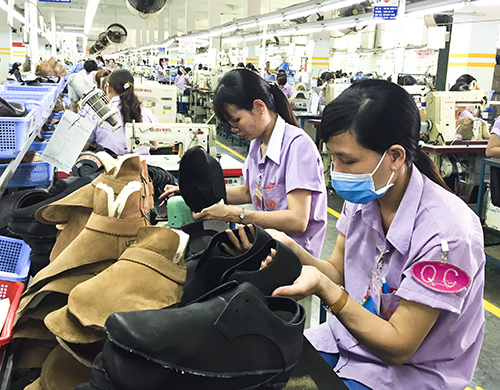 Mỗi DN được tôn vinh đều có những chính sách thiết thực chăm lo cho NLĐ. Trong ảnh: NLĐ Công ty TNHH Giày Uy Việt trong giờ sản xuất.