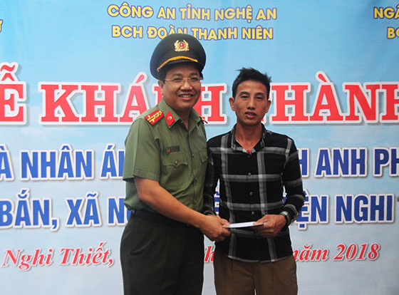 Đồng chí Đại tá Hồ Văn Tứ, Phó Giám đốc Công an tỉnh tặng quà mừng khánh thành nhà mới cho anh Phan Văn Trị
