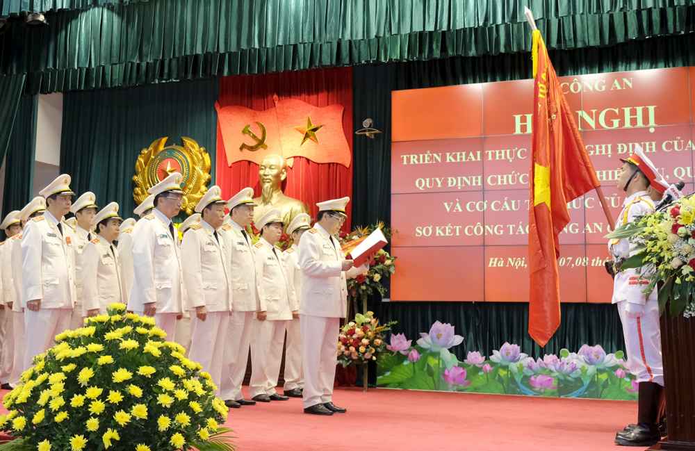 Lãnh đạo Bộ Công an tuyên thệ dưới cờ Tổ quốc Hội nghị triển khai Nghị định của Chính phủ quy định chức năng, nhiệm vụ, quyền hạn và tổ chức bộ máy Bộ Công an, 8/2018. Ảnh VGP/Quang Hiếu