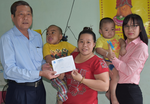 Đại diện Báo Bà Rịa - Vũng Tàu trao tiền của bạn đọc hỗ trợ gia đình chị Trần Thị Mai.