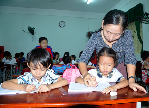 Cô Nguyễn Thị Hà, GV Trường TH Phước Thắng hướng dẫn HS viết bài  tại lớp 1 phổ cập giáo dục.