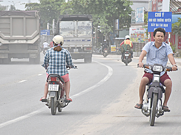Người điều khiển xe máy đi ngược chiều  và không đội mũ bảo hiểm trên QL 51,  đoạn qua phường Tân Phước (TX. Phú Mỹ).