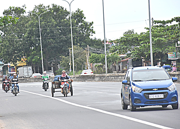 Xe máy và xe 3 gác đi vào làn ô tô trên QL 51,  đoạn qua phường Phước Hoà (TX. Phú Mỹ).