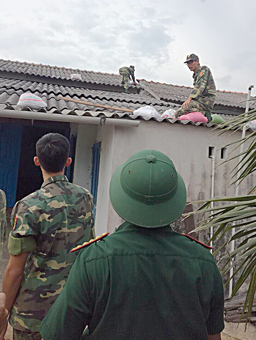 Bộ đội Biên phòng Đồn BP Bình Châu (huyện Xuyên Mộc) giúp dân chằng chống nhà cửa trước bão. Ảnh: HẠNH PHÚC