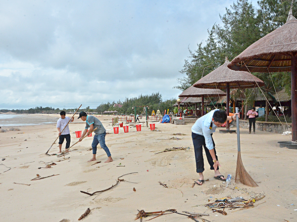 Nhân viên KDL Hương Phong-Hồ Cốc (huyện Xuyên Mộc) thu, dọn rác do triều cường đưa vào bãi biển.