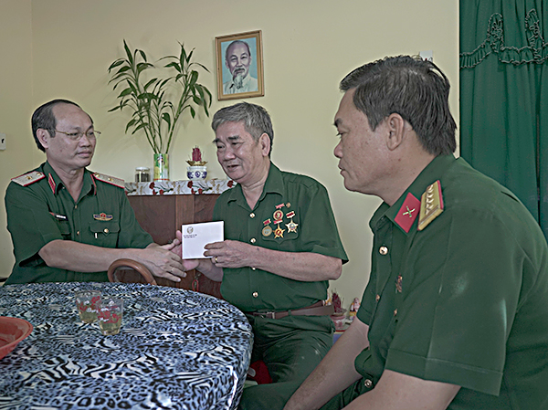 Thiếu tướng Nguyễn Văn Nam tặng quà cho cựu tù Côn Đảo Lê Văn Bảnh, Khu dân cư số 1. Ảnh: HUY BÌNH