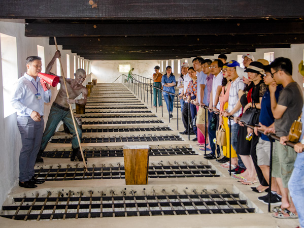Hướng dẫn viên giới thiệu đến du khách về di tích Trại giam Phú Tường, Trung tâm cải huấn Phú Hải.