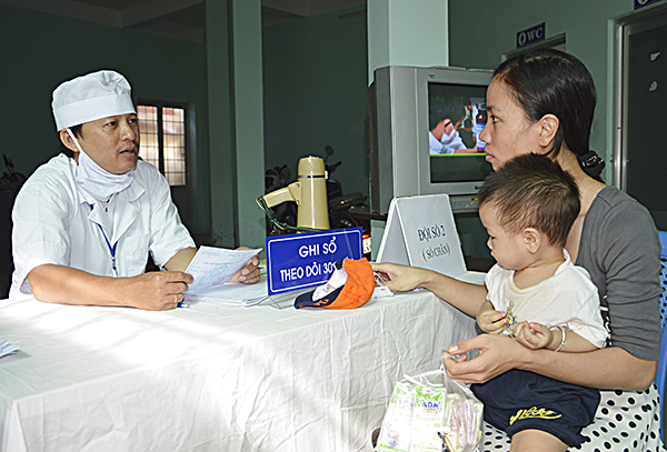Nhân viên Trạm y tế phường 7 (TP. Vũng Tàu) tư vấn cho phụ huynh theo dõi lịch tiêm và thông tin về vắc xin.