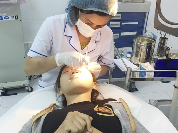 Chị Nguyễn Thị Nguyệt chăm sóc mắt cho bệnh nhân. 