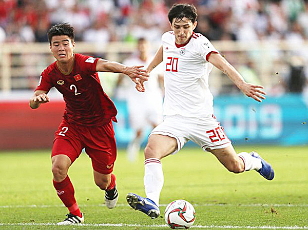 Việt Nam (trái) trong trận thua Iran 2-0.